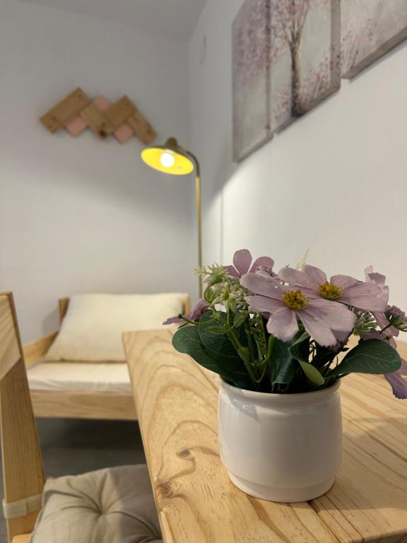 un jarrón con flores en una mesa en una habitación en Apartamentos El Búho, en Belmonte