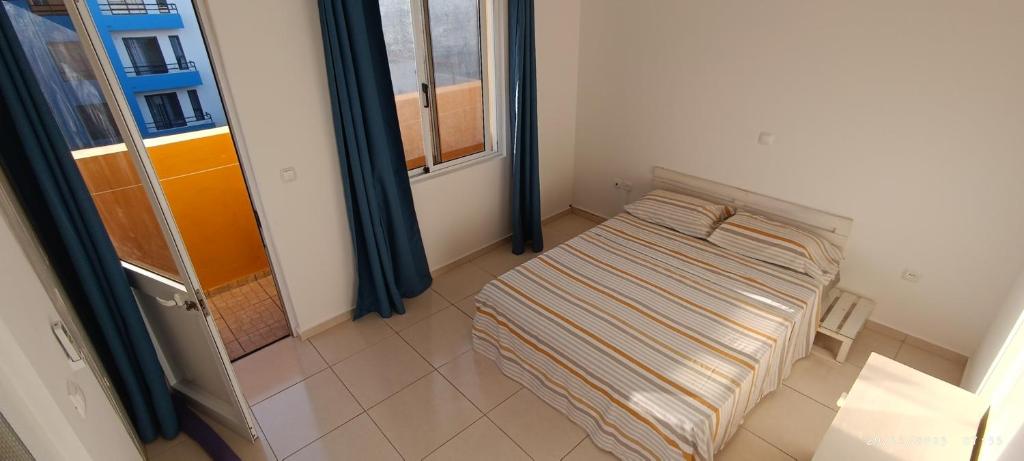 a small bed in a room with a window at Óscar guest house in Mindelo