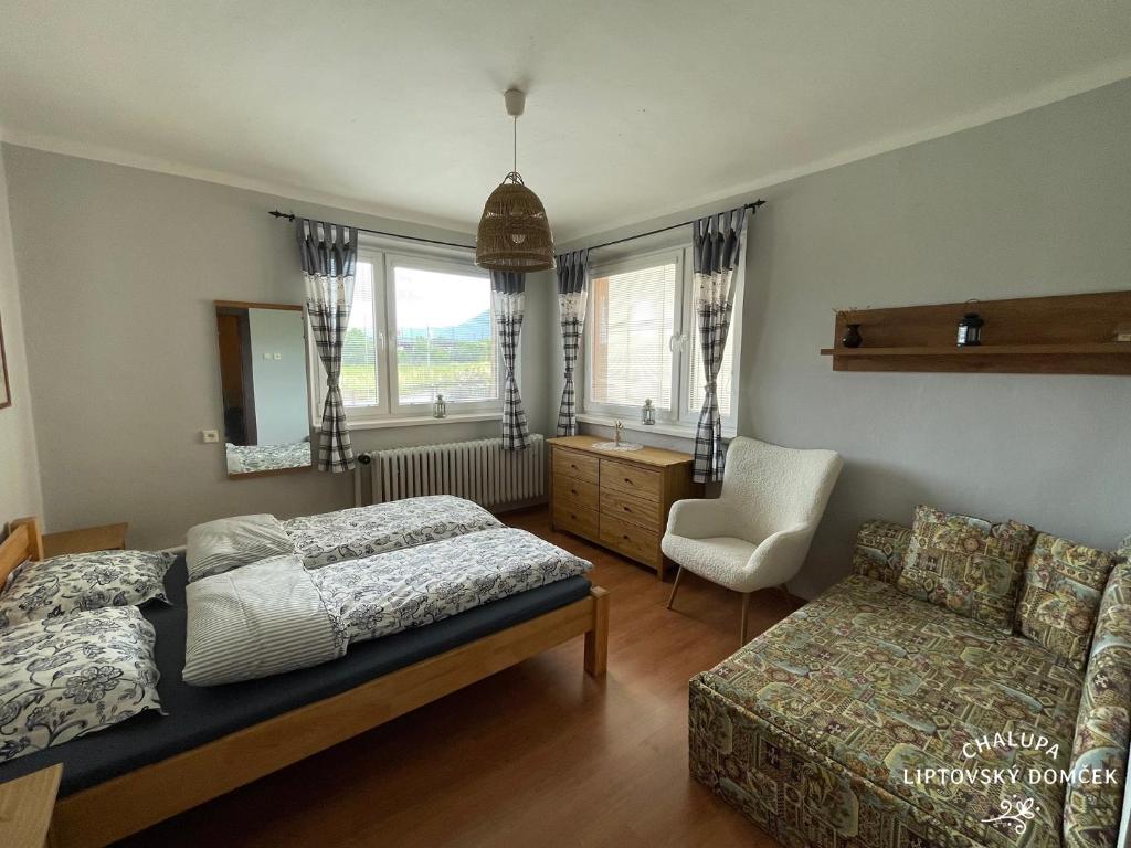 1 dormitorio con 1 cama, 1 sofá y 1 silla en Chalupa Liptovský domček, en Liptovský Mikuláš