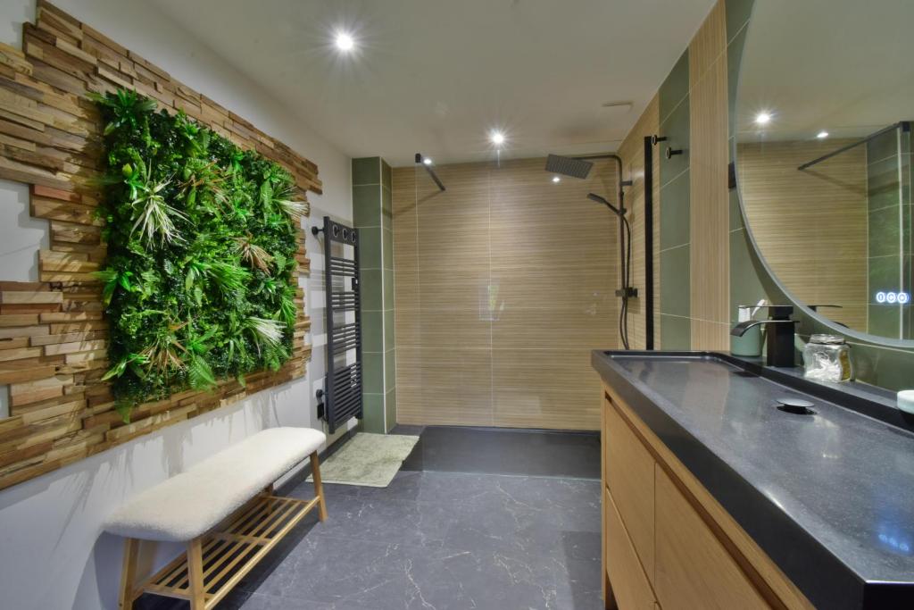 a bathroom with a green wall with a plant wall at Gite de groupe &quot;L&#39;Unisson&quot; Domaine La Rose des Vents in Castelnau-sur-lʼAuvignon