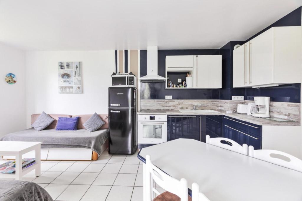 Il comprend une cuisine équipée d'un réfrigérateur noir et d'un canapé. dans l'établissement Résidence Port Bourgenay - maeva Home - Appartement 2 pièces 7 personnes - Sélection MAE-7339, à Talmont-Saint-Hilaire