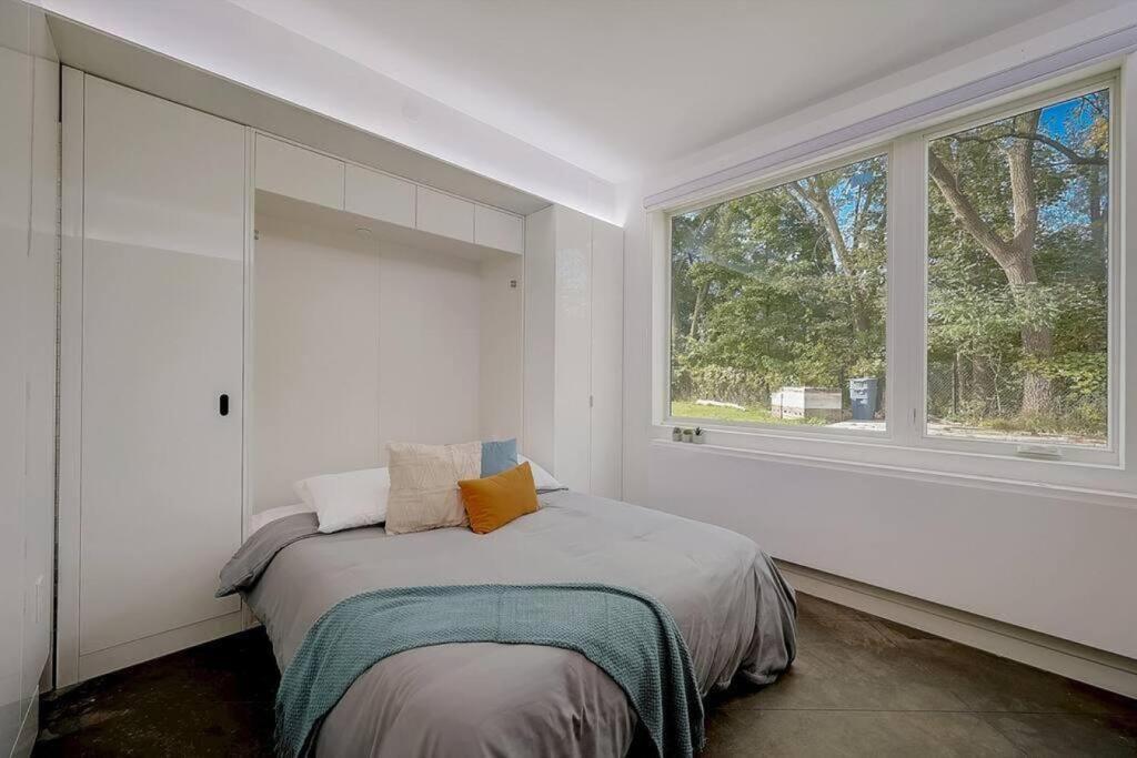 a white bedroom with a bed and a window at KCM Tremont Oaks Apartments 1 in Cleveland