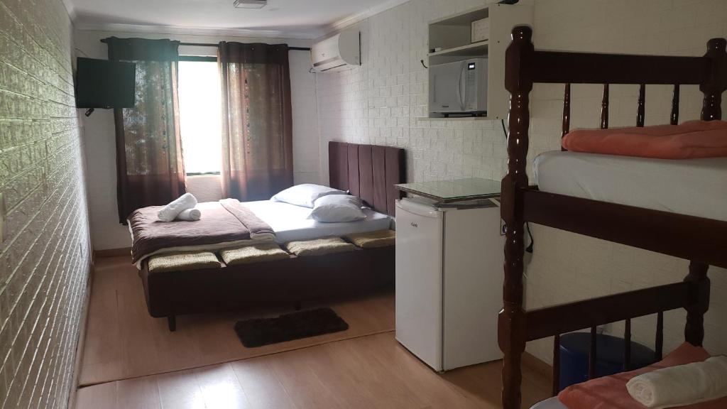 een kleine slaapkamer met 2 stapelbedden en een raam bij Paz e Amor Suite in Abraão