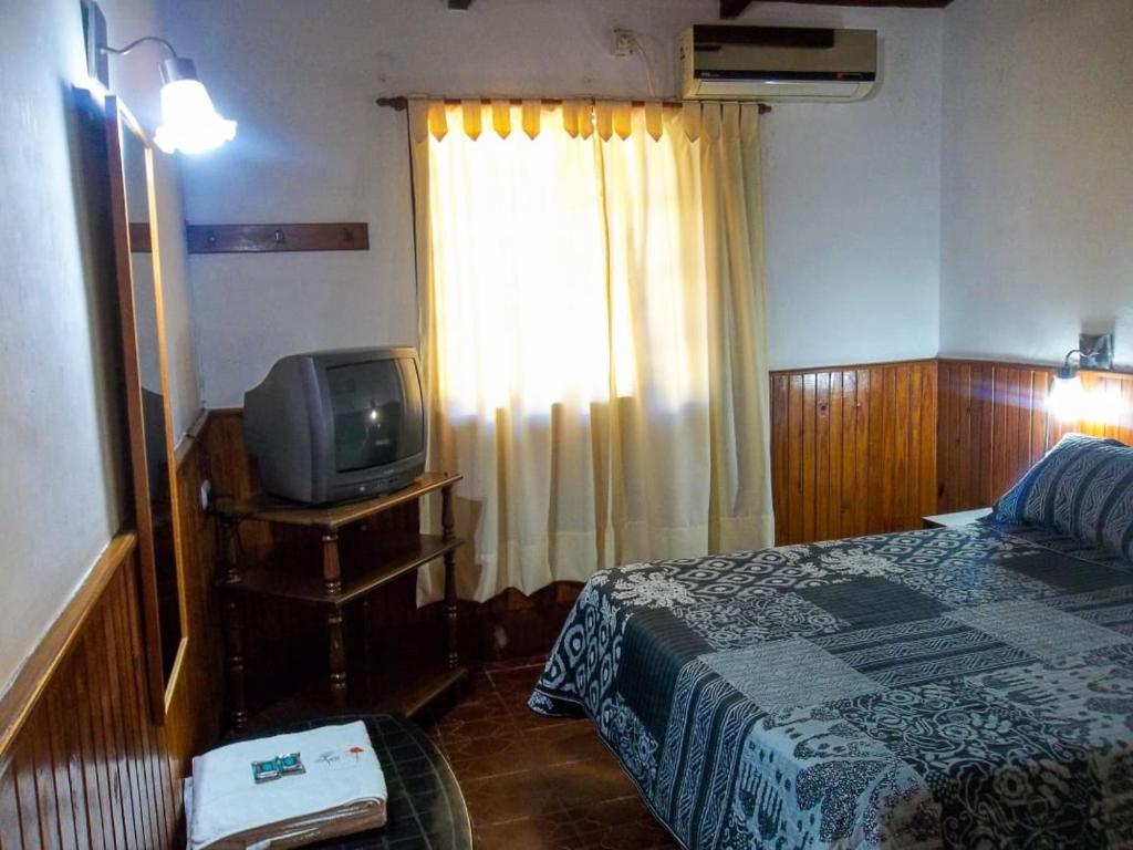 Schlafzimmer mit einem Bett und einem TV in der Unterkunft Apart Cuidad de Córdoba in Termas de Río Hondo