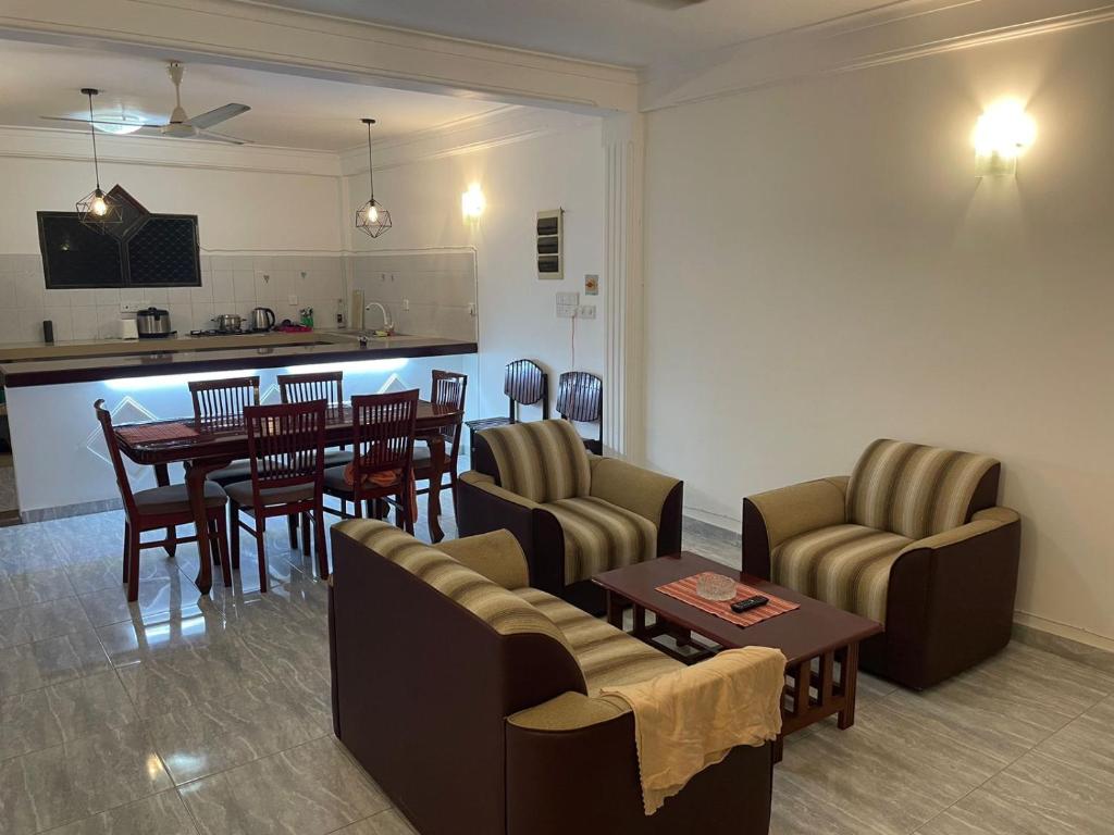 a living room with a table and chairs and a kitchen at Wonder Homestay in Negombo