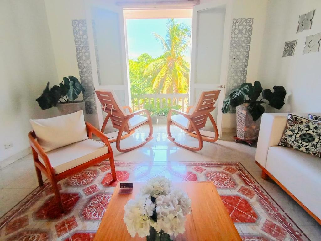 ein Wohnzimmer mit 2 Stühlen und einem Couchtisch in der Unterkunft Hotel AT THE PARK in Cartagena de Indias