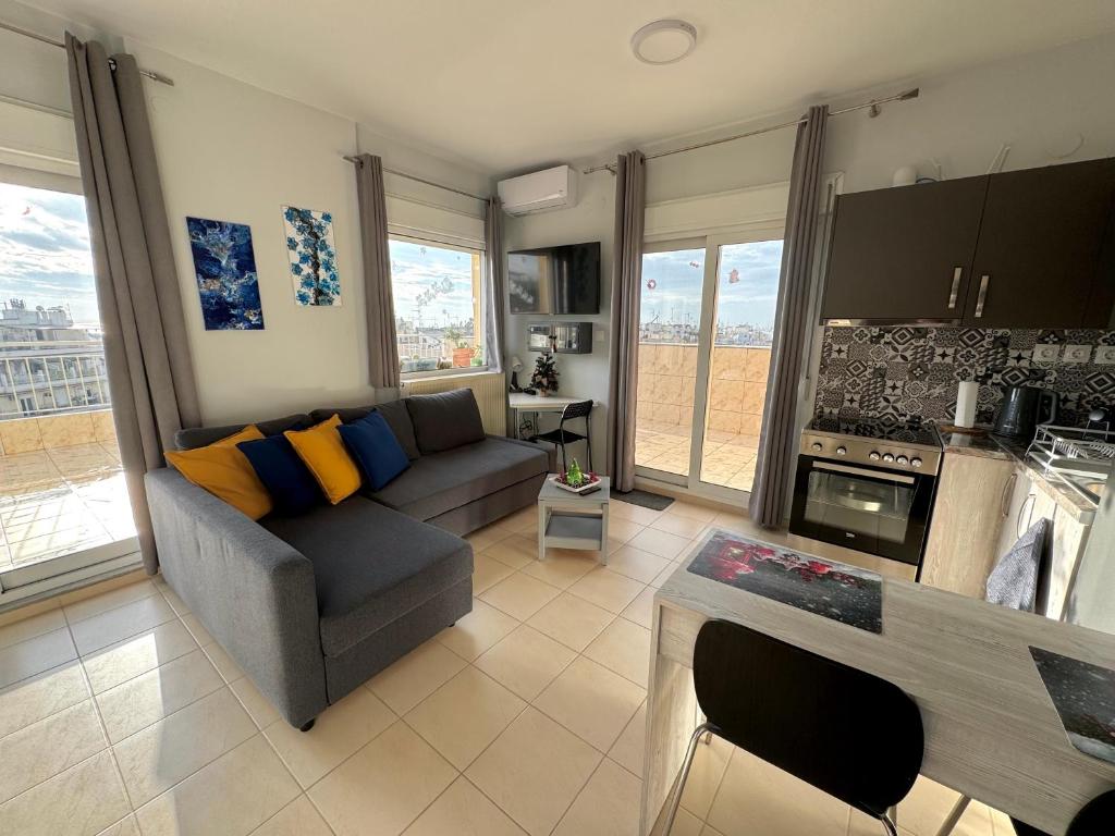 un soggiorno con divano e una cucina di Horizon /Downtown Penthouse w/ massive terrace a Salonicco