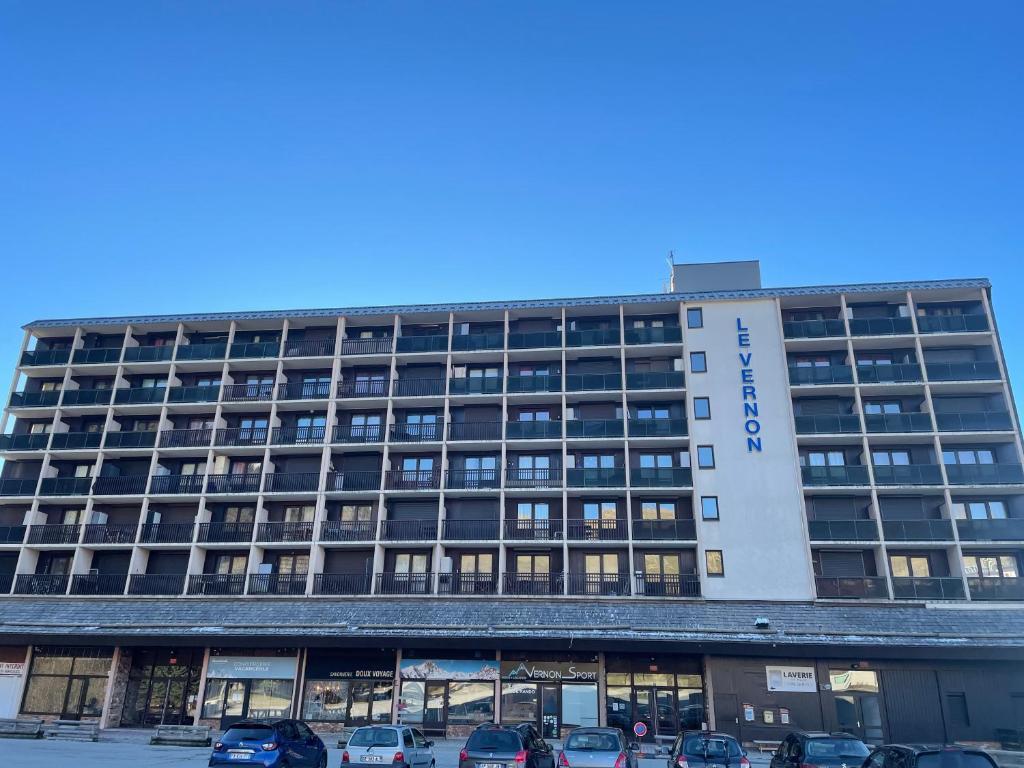 a hotel with cars parked in front of it at Studio Cabine Chamrousse in Chamrousse