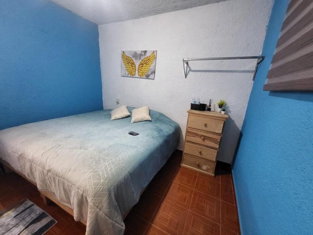 a blue bedroom with a bed and a dresser at Visita Pachuca junto a familia , 2 Recamaras 1- cama ks , Recamara 2 -1 Cama KS , baño privado , 1 Comedor (Refrigerador, desayunador, estufa ) in Pachuca de Soto