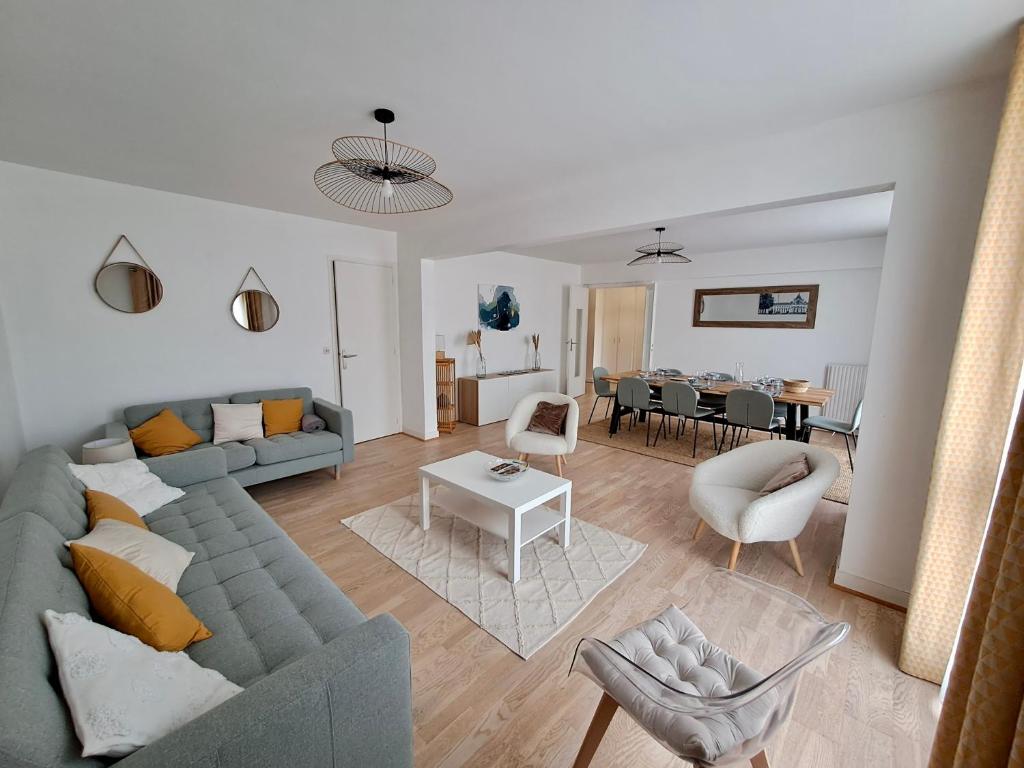 Una sala de estar con un sofá y un comedor. en Very beautiful apartment right in the center, en Versalles