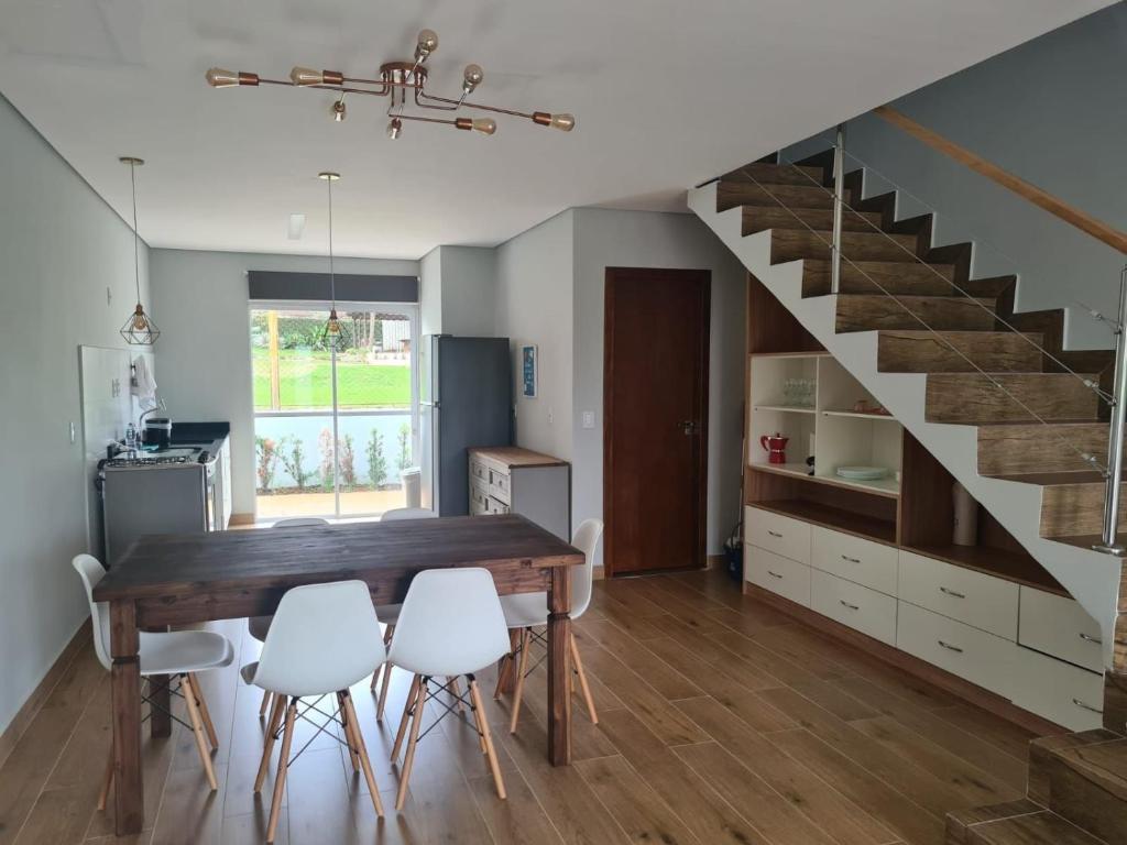 uma cozinha com uma mesa de jantar e uma escada em Casas de alto padrão em Condominio Privado em Chapada dos Guimarães
