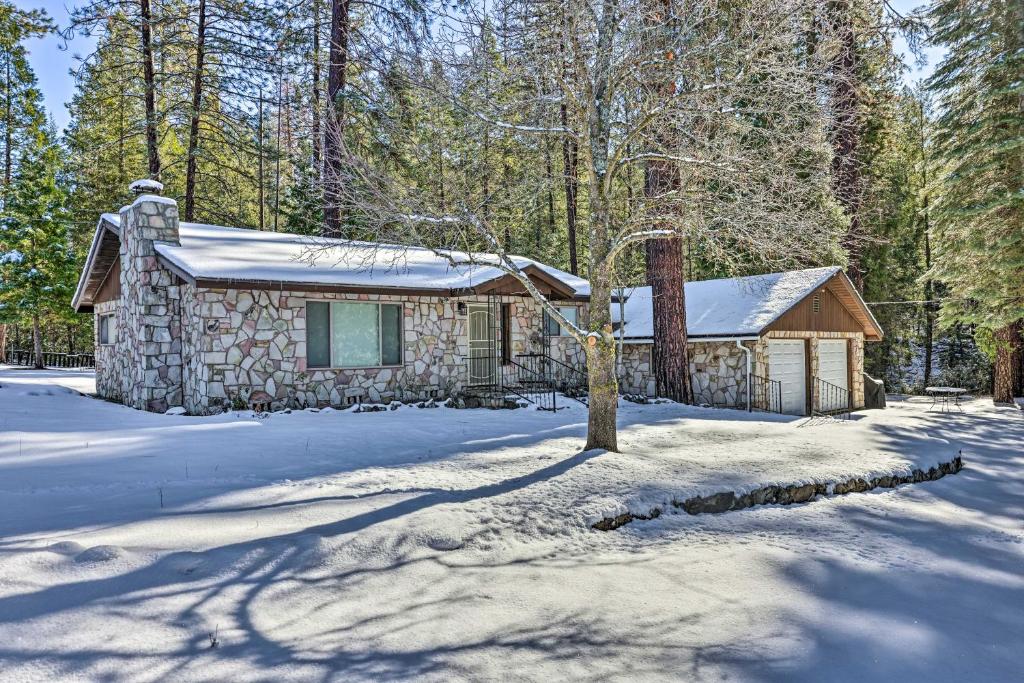 eine Hütte im Wald mit Schnee auf dem Boden in der Unterkunft Riverfront Home near Yosemite National Park! in Groveland