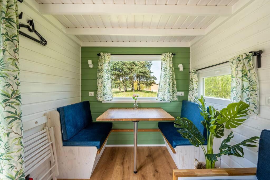 een tiny house met een tafel en blauwe stoelen bij Green Tiny Safari in Zeewolde