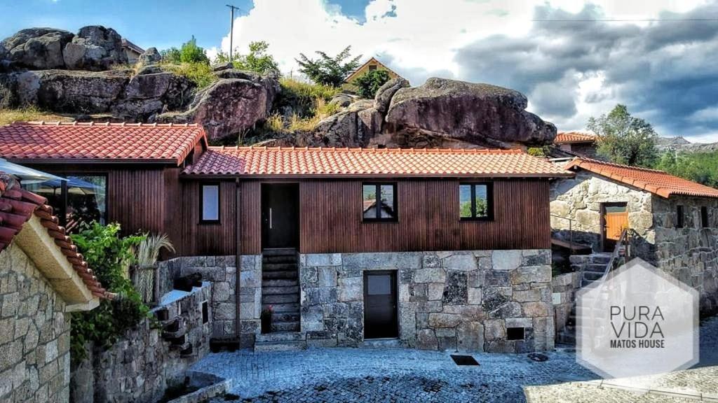 a stone house with a sign in front of it at Pura Vida Matos House in Fafião