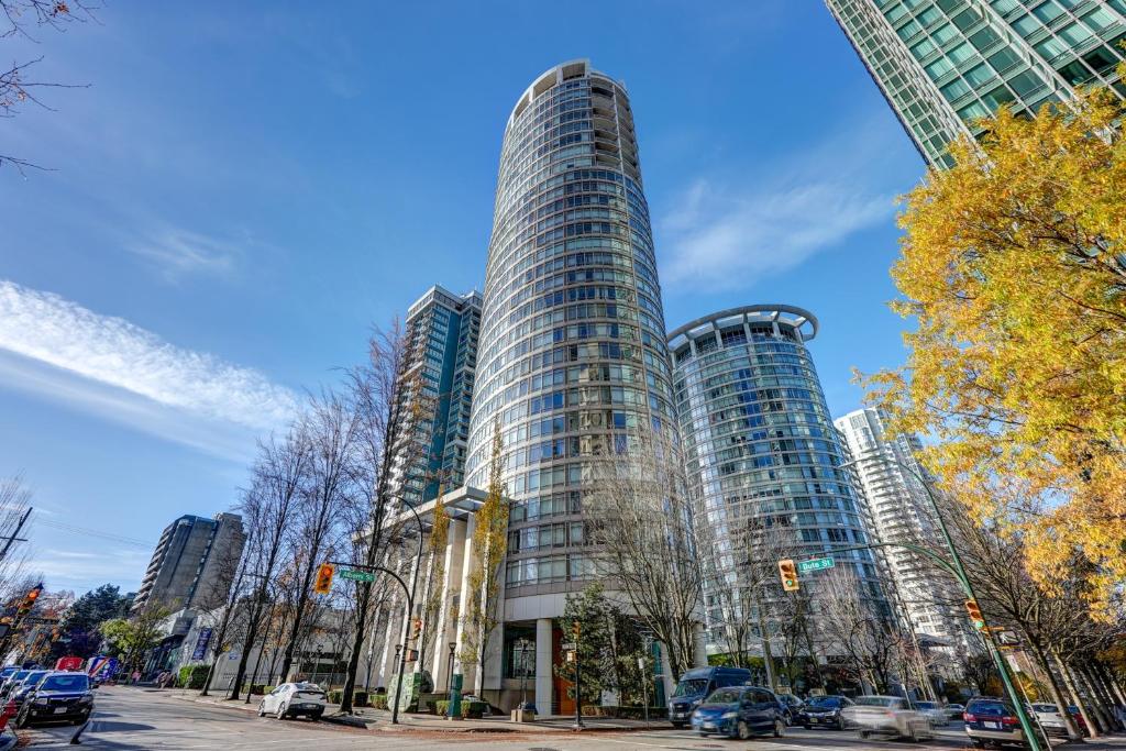 un edificio alto con coches estacionados frente a él en Dunowen Properties, en Vancouver