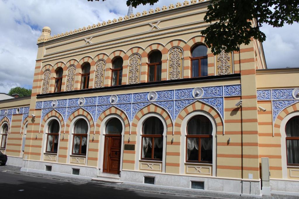 un antiguo edificio azul y amarillo en İsa Begov Hamam Hotel, en Sarajevo