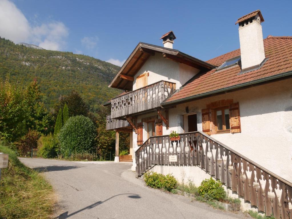 a house with a wooden fence next to a road at Appartement 4 personnes Lac d'Annecy in Lathuile