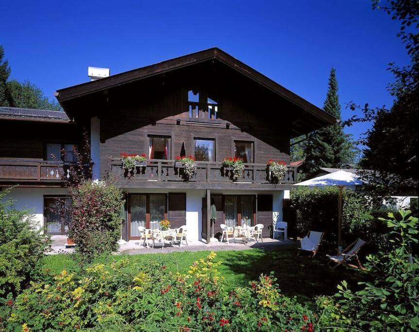 Cette grande maison dispose d'un balcon, de tables et de chaises. dans l'établissement Suite Werdenfels, à Garmisch-Partenkirchen
