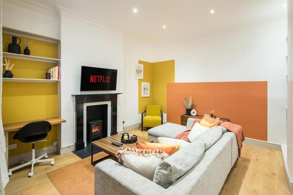 uma sala de estar com um sofá e uma lareira em Superb Retreat Central Next Tube em Londres