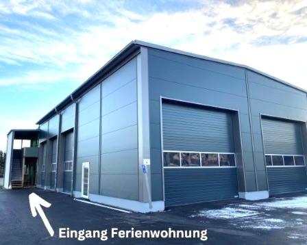 a large metal building with two large garage doors at Ferienwohnung Hüttenflair in Amberg