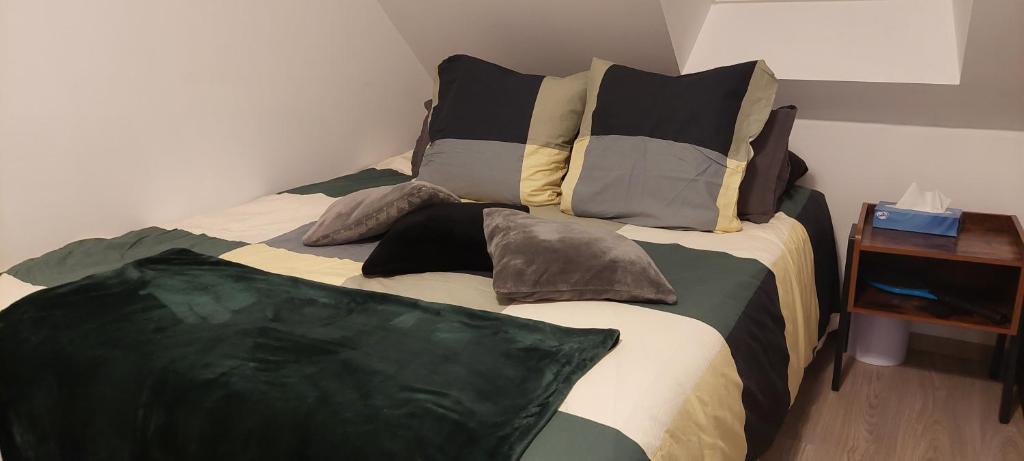 una cama con almohadas en una habitación en Studio duplex à Savenay en Savenay