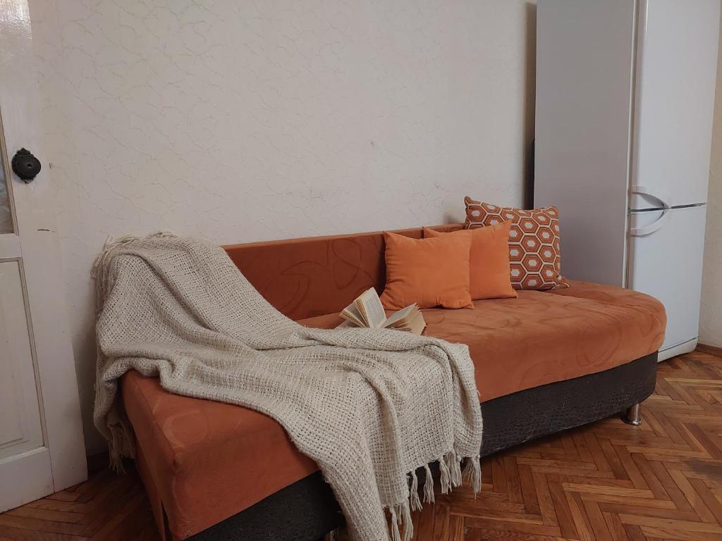 a couch with a blanket on it in a room at Економ у центрі 3 кімнати in Luts'k