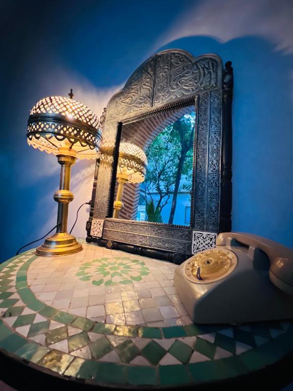 a table with a mirror and a lamp on it at Riad Al Nour in Marrakech