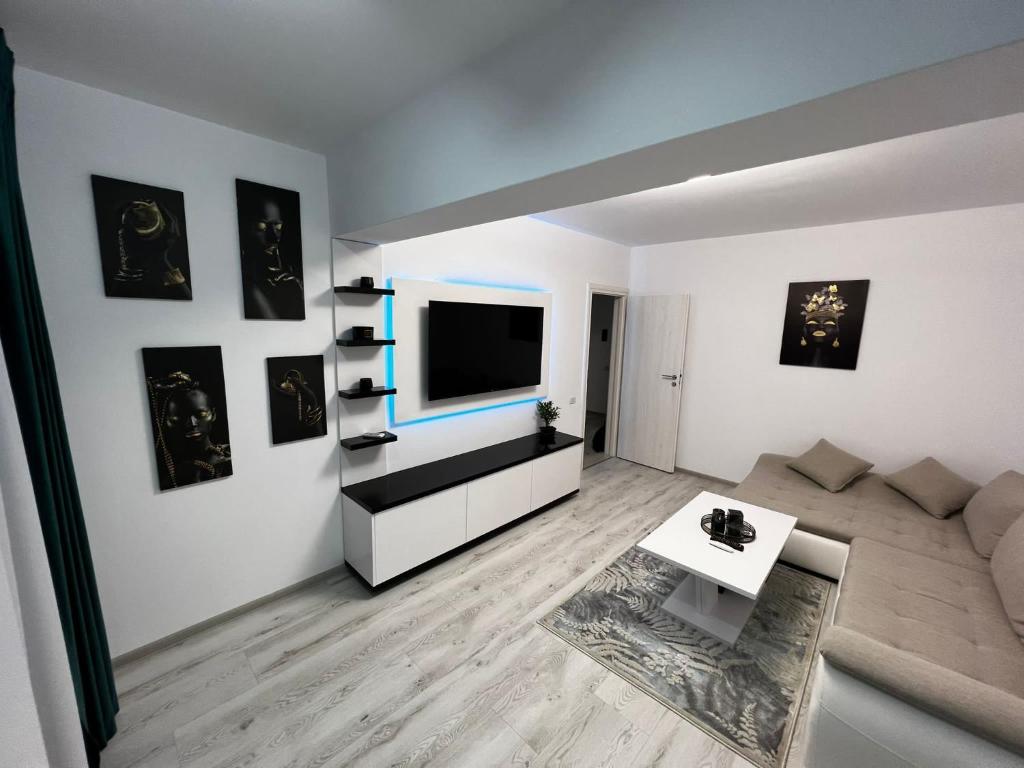 - un salon avec un canapé et une télévision murale dans l'établissement Amelia Apartment, à Braşov