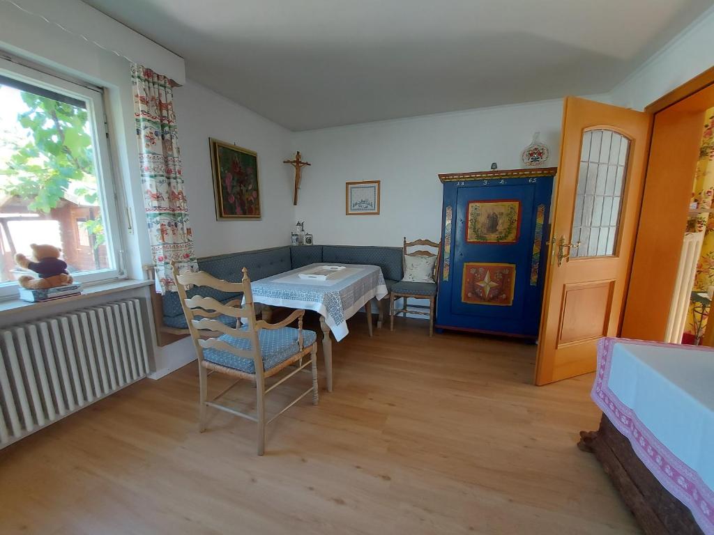 un soggiorno con tavolo, sedie e finestra di Ferienwohnung Grünwald a Grünwald