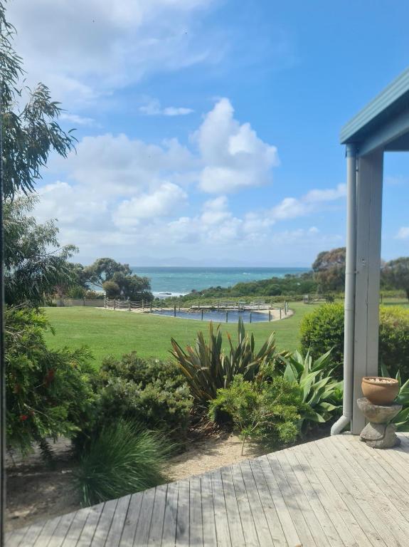 a view of the ocean from the porch of a house at Bear Gully Coastal Cottages in Walkerville