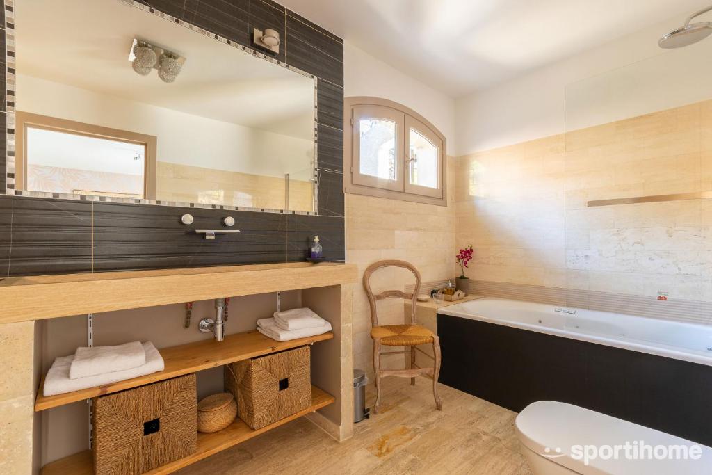 a bathroom with a tub and a large mirror at Le Mas des Roches à Velaux in Velaux