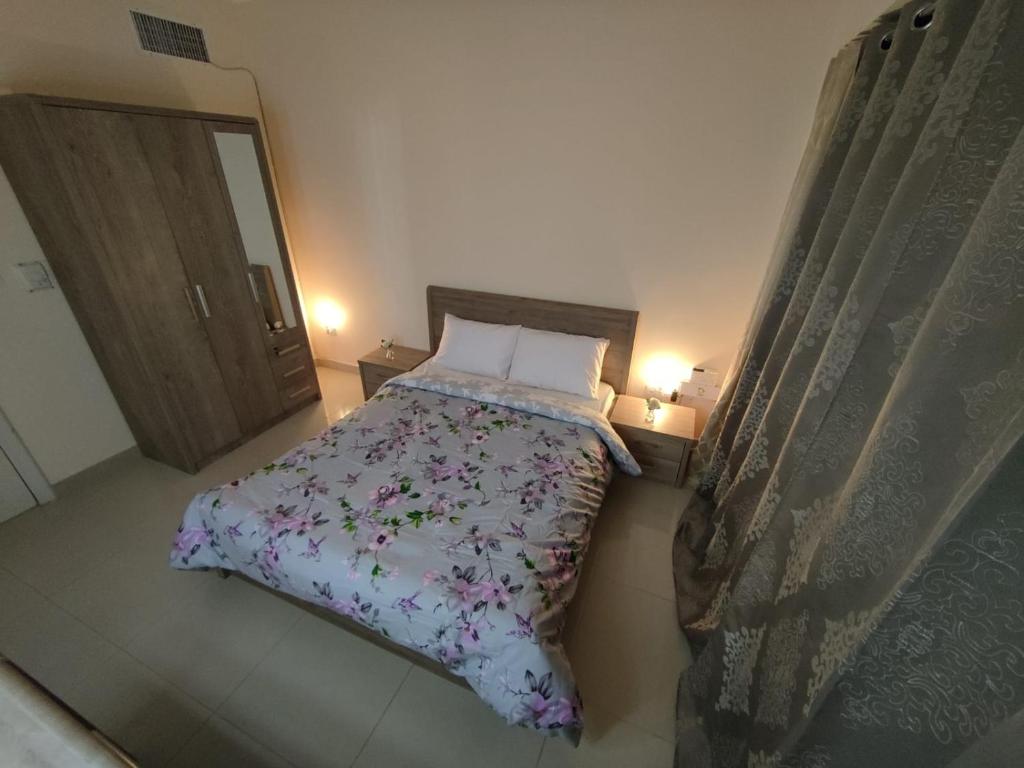 - une chambre avec un lit et une couette en fleurs dans l'établissement Bedroom 3, Couples should be married, à Abu Dhabi