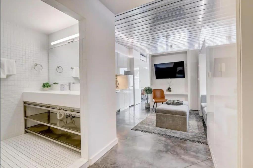 a bathroom with a tub and a sink and a tv at KCM Mikros Smart Apartments 6 in Cleveland