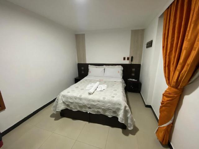 Postel nebo postele na pokoji v ubytování Hotel Yolima Real