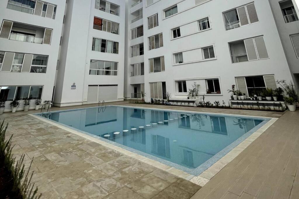 a swimming pool in front of a building at Appartement avec piscine - Mohammadia in Mohammedia