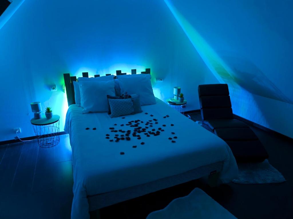 1 dormitorio azul con 1 cama y 1 silla en Les Secrets d'Amandine en Troguéry