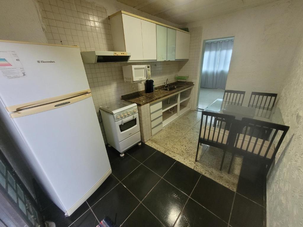 a kitchen with a white refrigerator and a table at Casa Cmc011 Simples e Objetiva Com Estacionamento in Brasilia