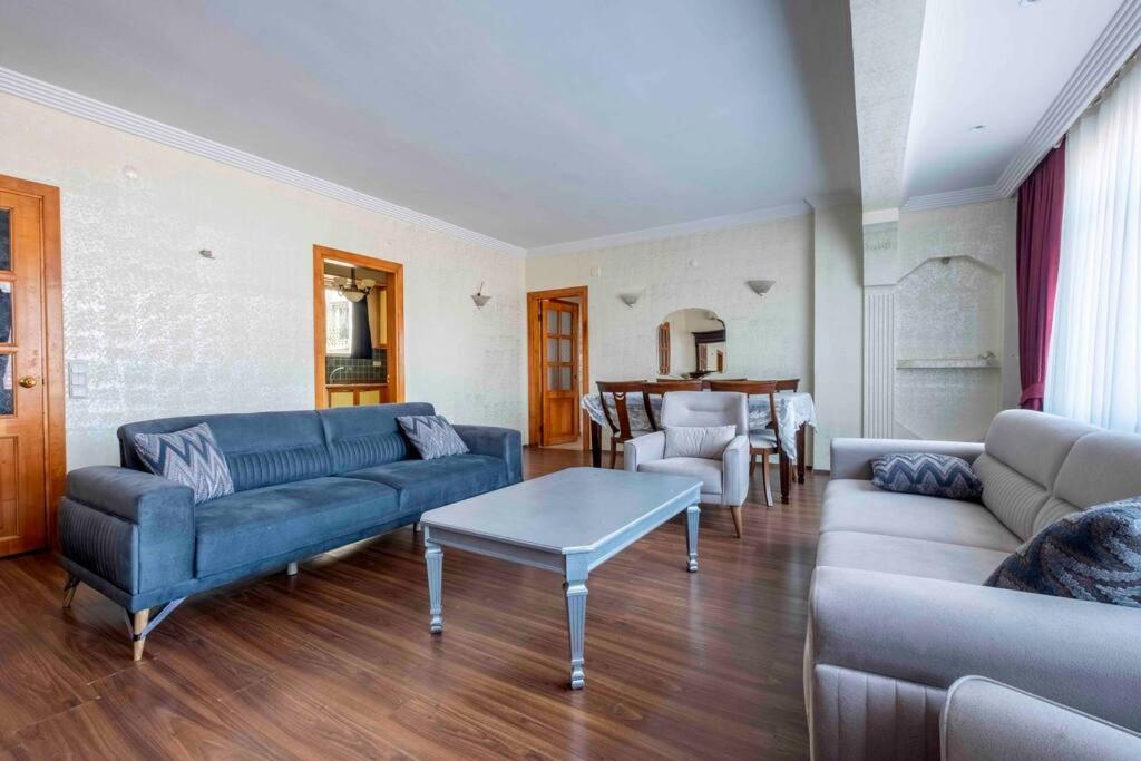 a living room with a blue couch and a table at Bakırköy'de ailecek konaklayabilceginiz daire in Istanbul