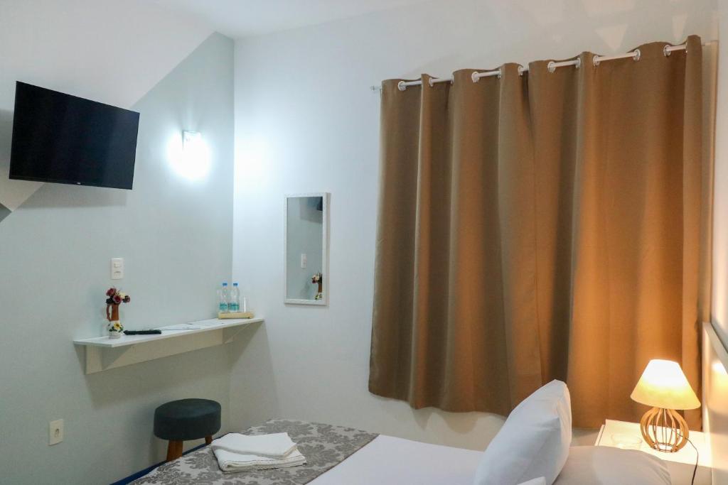 a hotel room with a bed and a curtain at Metro Hotel in Águas de Lindoia