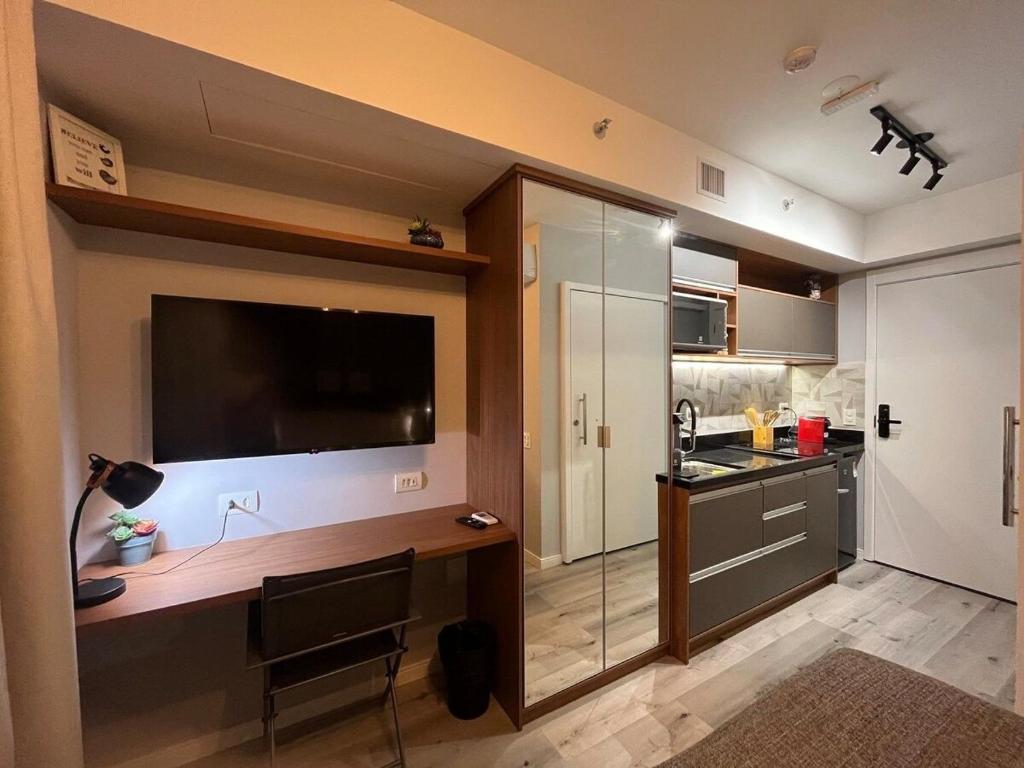 a kitchen with a desk and a television in a room at Studio 201 SP Moema Super Equipado in Sao Paulo