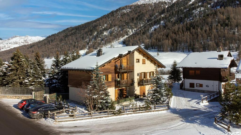 dom z samochodem zaparkowanym przed nim w śniegu w obiekcie Dany Lodge Livigno w Livigno