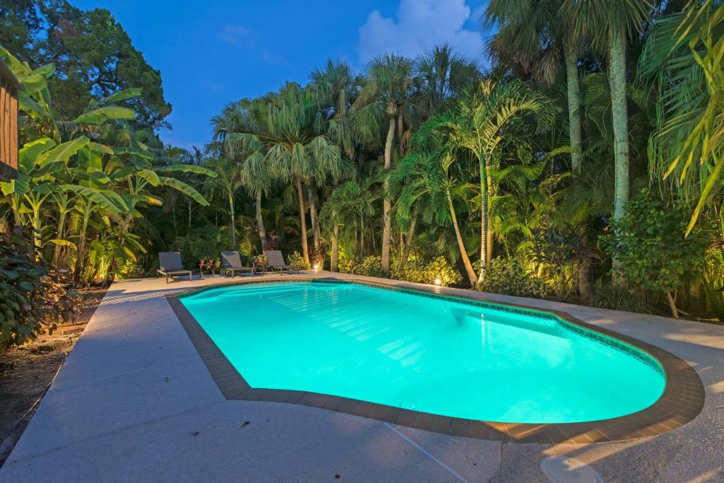 een zwembad in een tuin met palmbomen bij Palm Paradise - Pet Friendly Home on Siesta Key w/ Large Heated Private Pool & Outdoor Area! in Sarasota