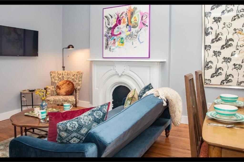 a living room with a blue couch and a fireplace at 3BR Central Park in New York