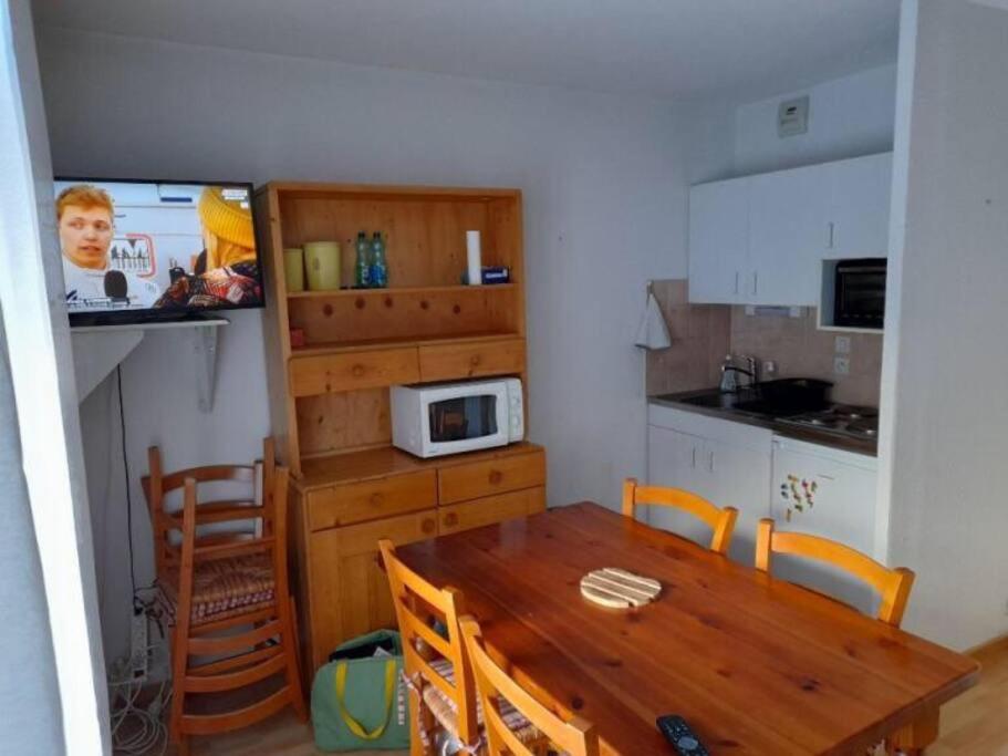une cuisine avec une table en bois et un micro-ondes dans l'établissement Les contamines Montjoie 1 CHAMBRE 4 personnes, aux Contamines-Montjoie