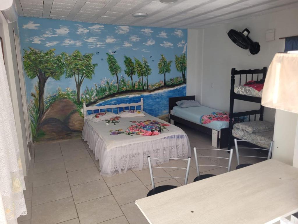 una camera con un letto e un dipinto sul muro di Pousada Cantinho Azul a Passo de Torres