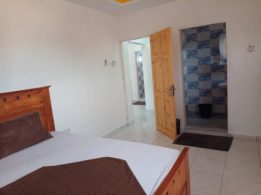 a bedroom with a bed and a door to a bathroom at Suleimane guest in Sere Kunda