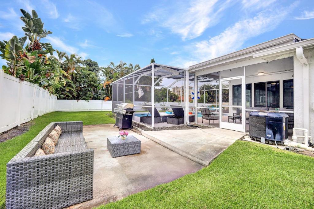 a backyard of a home with a glass house at Beach Daze - Summer Sale! Southern Facing Pool, Walk To The Beach - No Ian Damage! in Naples
