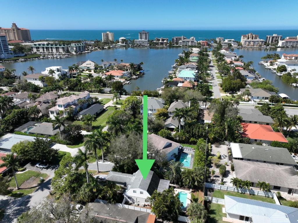arial view of a city with a green arrow pointing to a house at FALL SPECIAL! Seas The Day - This one has it all - Walk to Vanderbilt beach! in Naples