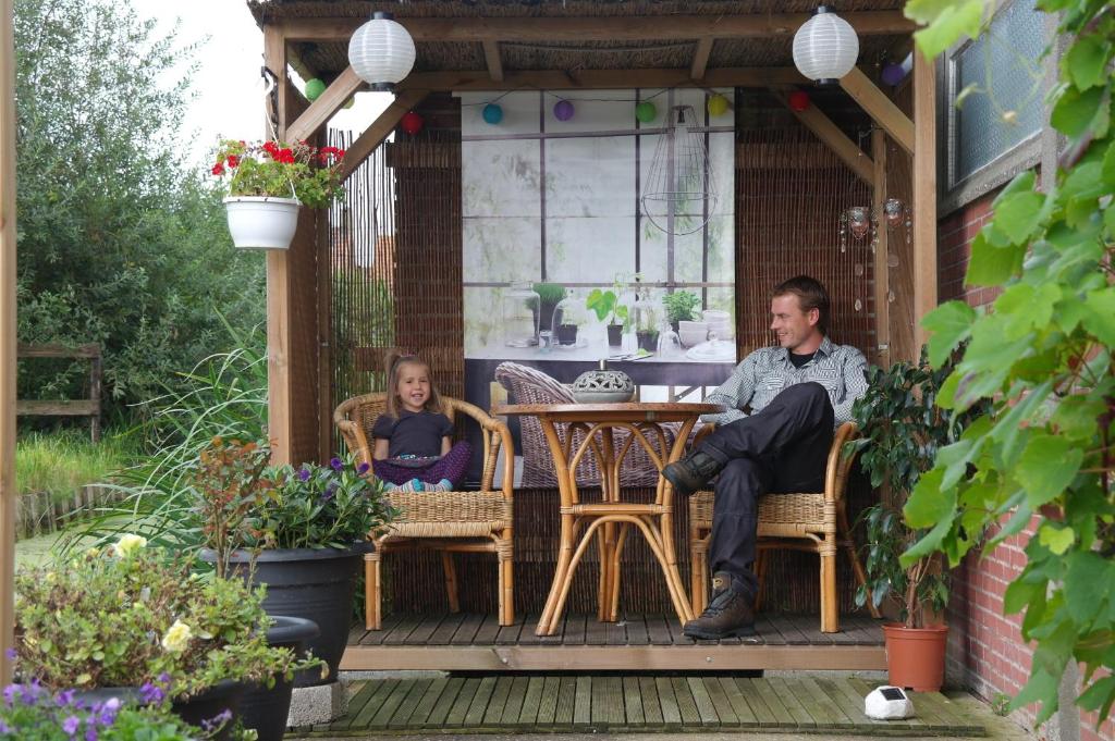 een man en een vrouw aan een tafel op een patio bij B&B Dirosa in Onderdijk