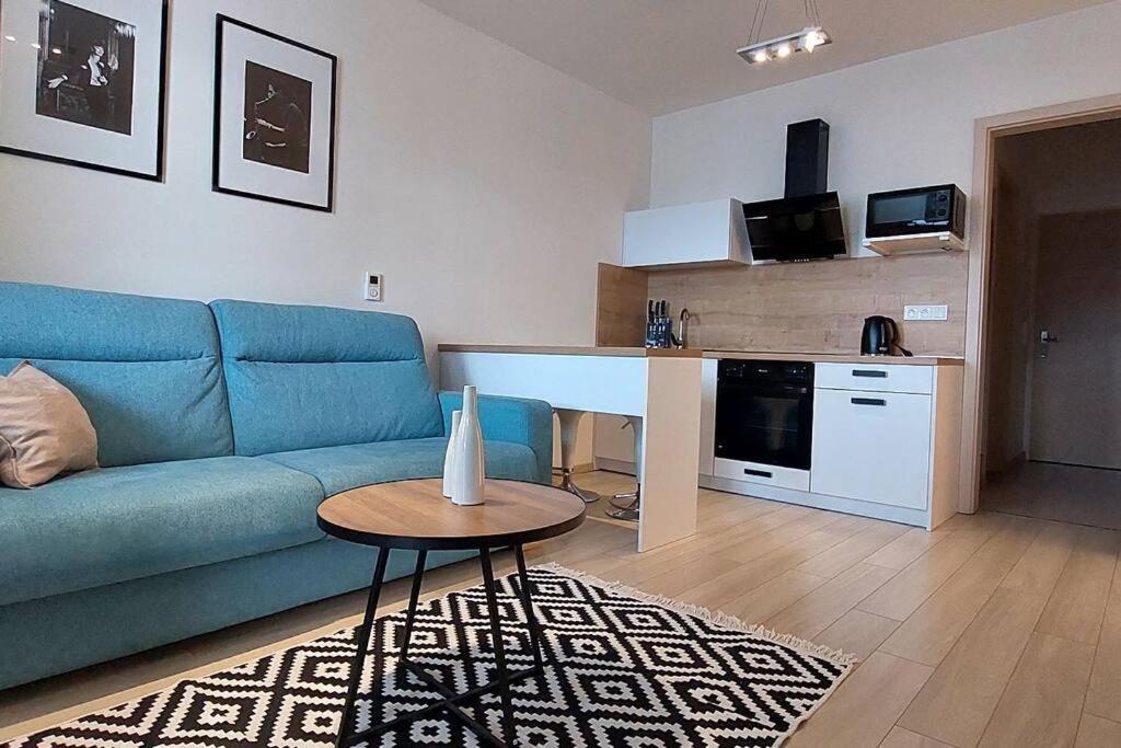 - un salon avec un canapé bleu et une table dans l'établissement Apartmán Soul 200 m do centra s private parking, à Košice